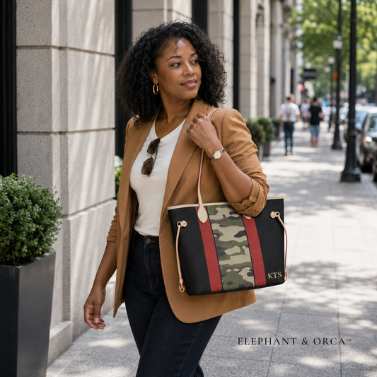 Woman carrying a personalized crimson and camouflage vegan leather handbag by the shoulder handles.